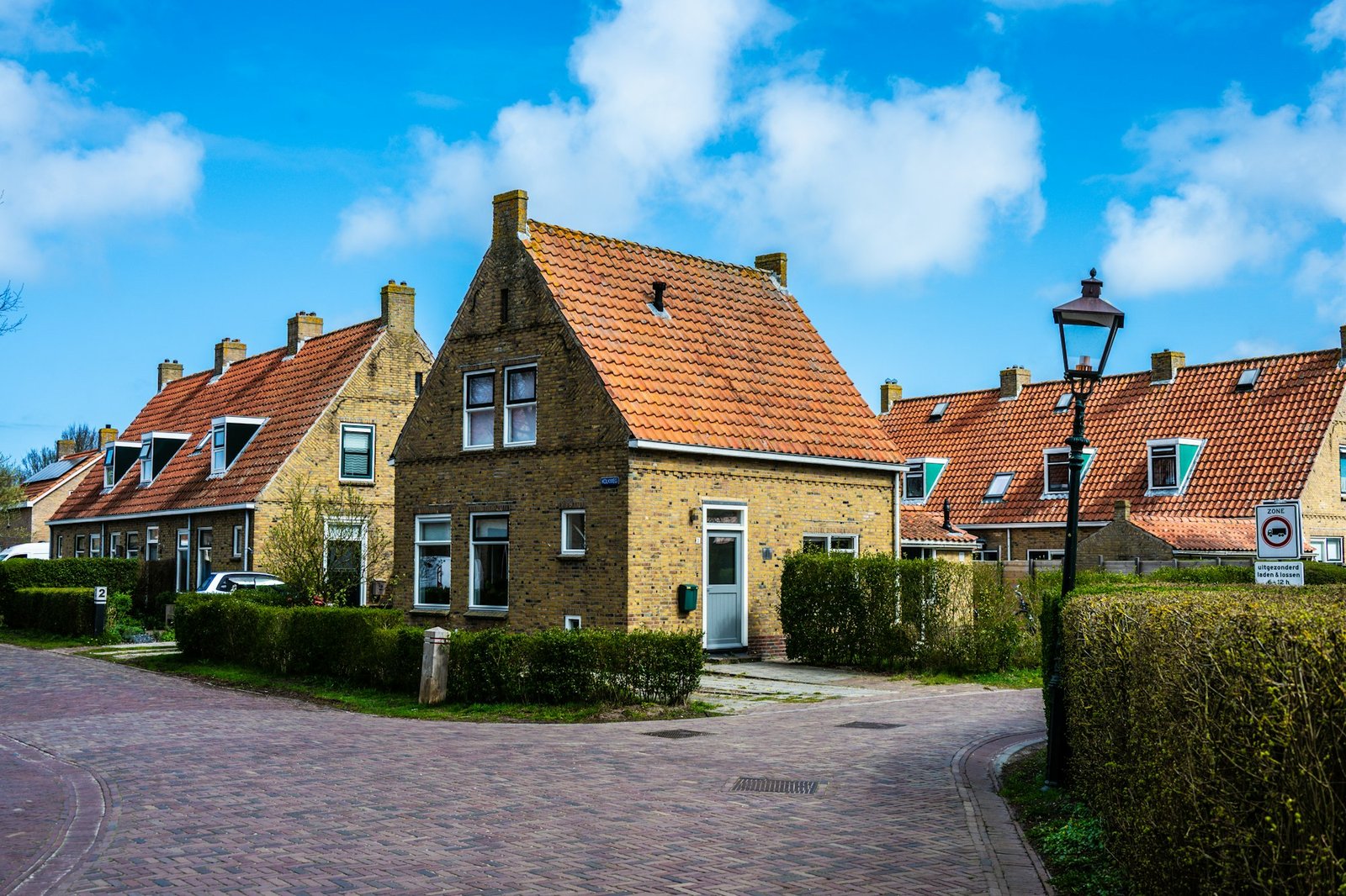 Een straat met rijtjeshuizen van rode baksteen