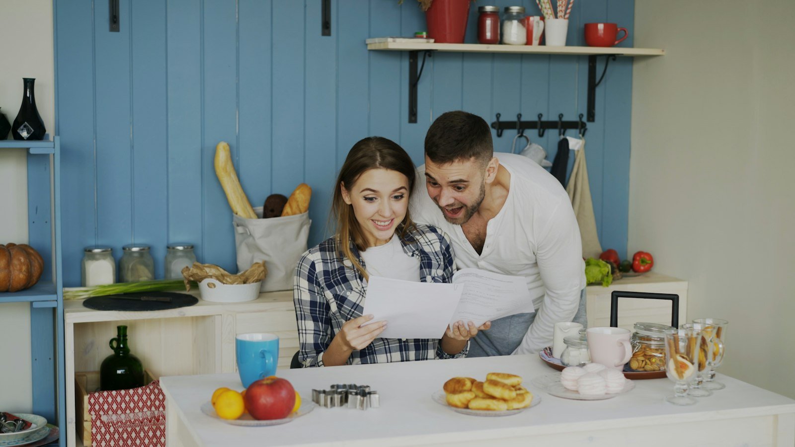 Een stel bekijkt samen papieren in een lichte keuken